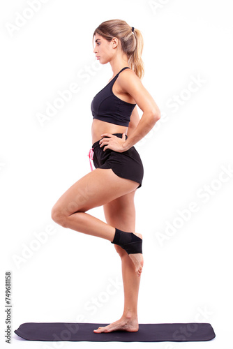 Athletic girl on a fitness mat on a light background