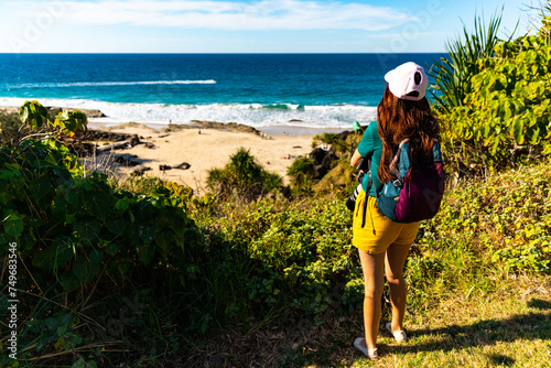 girl looking for whales from the cliffs of point danger above duranbah beach in coolangatta near gold coast, queensland, australia; relaxing coastal walk in a scenic area photo