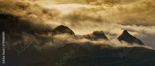 Silhouettes of panoramic view of mountains shrouded in clouds and mist. Lofoten, Northern Norway. photo