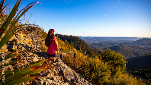 beautiful hiker girl enjoying sunset over unique, folded mountains in south east queensland, australia; main range national park near brisbane, bare rock lookout	 photo