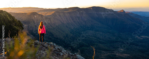 beautiful hiker girl enjoying sunset over unique, folded mountains in south east queensland, australia; main range national park near brisbane, bare rock lookout photo
