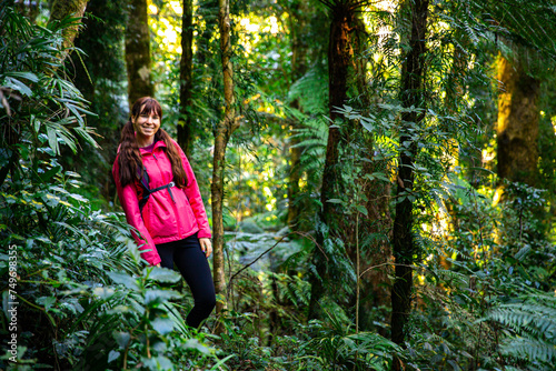 hiker girl with a backpack walking through a dense gondwana rainforest in lamington national park, queensland, australia; hiking in green mountains, toolona circuit, forest with unique ancient plants