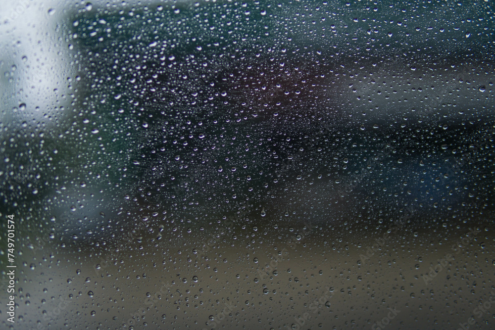 Water drop on​ glass of​ car​ on​ the​ Road​ in rainy season.