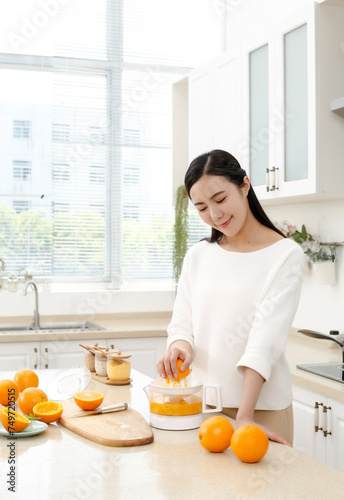 Asian girl making juice in kitchen