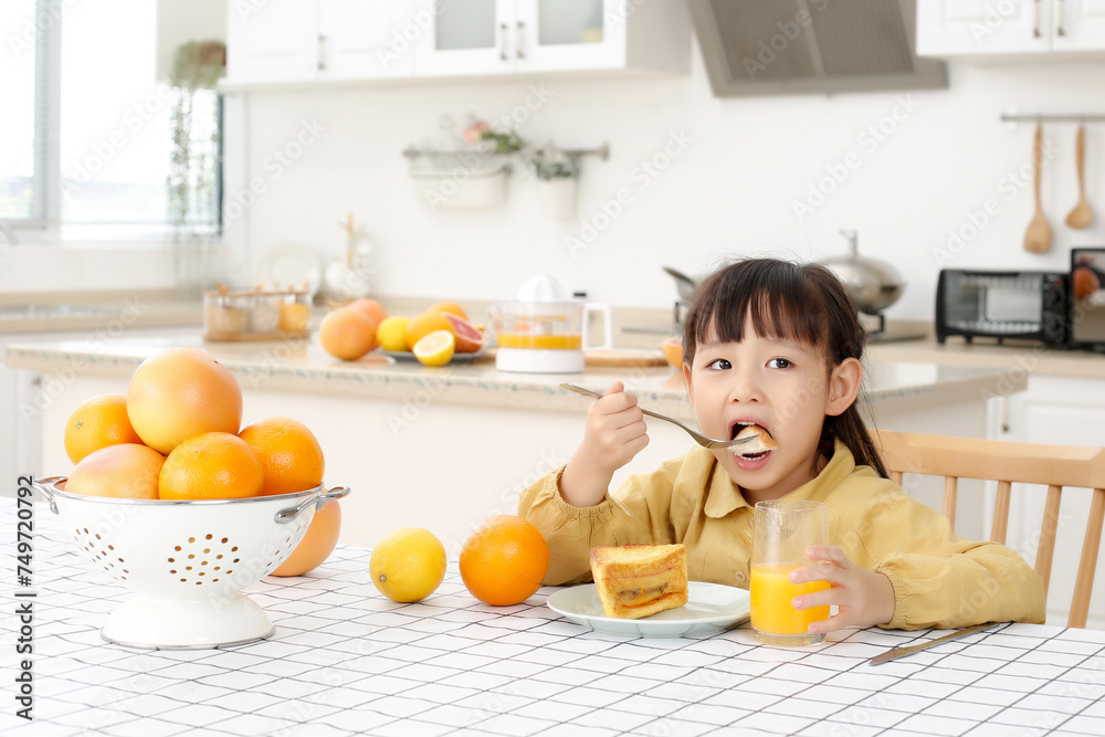 Made in kitchen Asian daughter drinks juice and eats bread