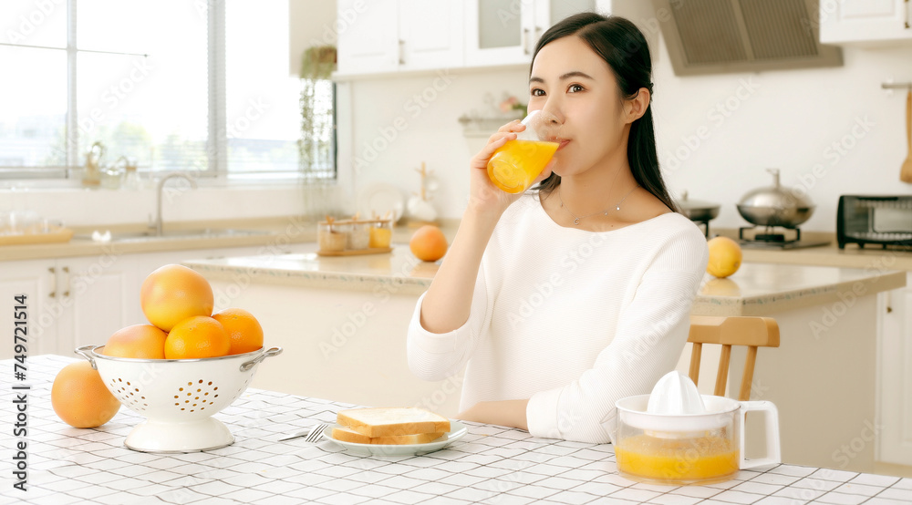 Asian girl drinking juice in kitchen