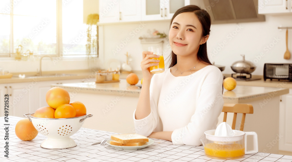 Asian girl drinking juice in kitchen