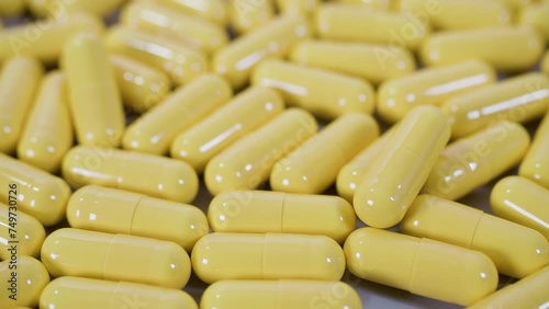 Tablets pills spilling from plastic pill bottle on natural background with selective focus. Pills for heart and vascular system support. 