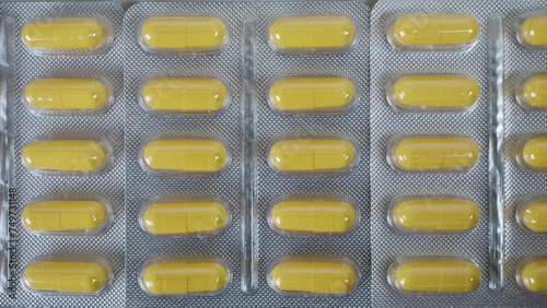 Tablets pills spilling from plastic pill bottle on natural background with selective focus. 
