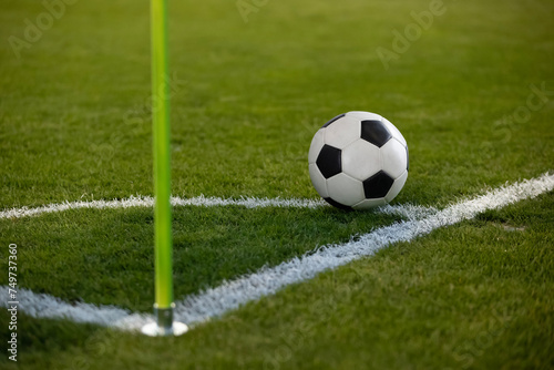 Close up photo of a soccer ball resting on the corner circle ready for a corner kick during a soccer game. Selective focus on the ball. Good generic soccer image. © Brocreative