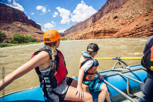Active young family enjoying a fun whitewater rafting trip down the Colorado River. Fun in the sun as they head down the river.