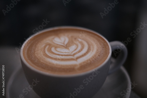 Cup of coffee latte with heart shape in cafe in coffee shop with hand 