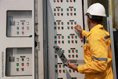 The electrical engineer checks and inspects at MDB panel (Main Distribution Board ) in the Substation building, daily and checks the electric switchboard on the Main Distribution Boards of the factory photo