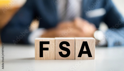 White table with FSA blocks representing flexible spending account, symbolizing financial planning and benefits allocation photo