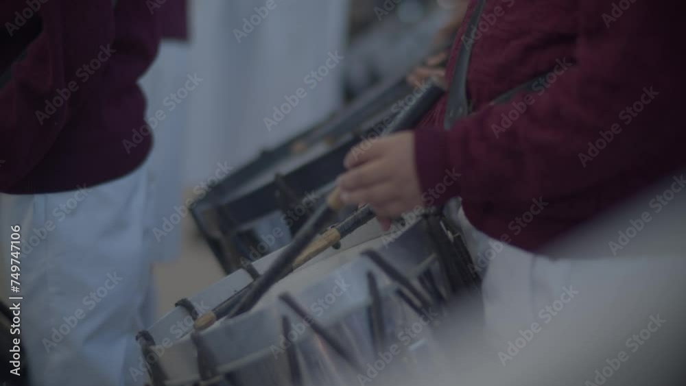 manos de niños tocando el tambor escolar