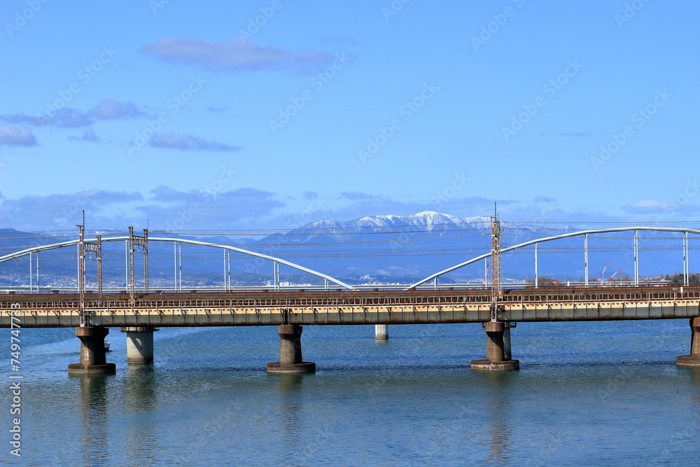 雪の積もった蓬莱山と瀬田川を渡る橋
