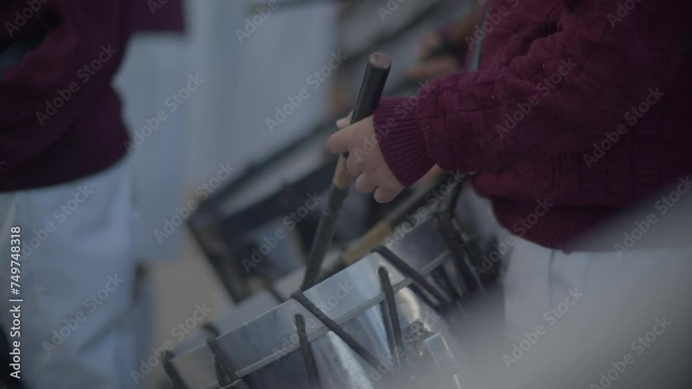 manos de niños tocando el tambor escolar