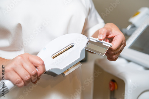 A therapist holding a laser for epilation at cosmetic beauty spa clinic.