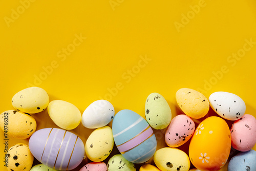 Multi-colored Easter eggs on a yellow spring background. Happy easter