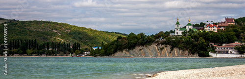 View of the church on the mountain. View of Lake Abrau-Durso from the shore. In the village of Abrau-Durso, on the mountain stands the Church of Blessed Xenia of Petersburg.
