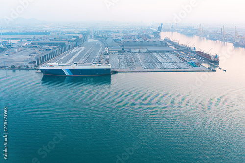 Aerial top view of ro-ro ship of business logistic sea freight, large industrial import-export ports prepare to load containers
global transportation and logistic business international order concept. photo
