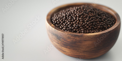 Piper cubeba, cubeb, pepper on bowl made of wood. copy space text available. photo