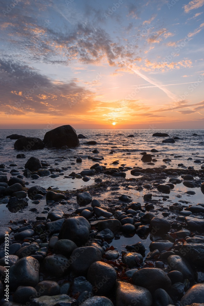 Amazing seascape with stony coast and epic sunrise.