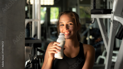 Healthy lifestyle woman drink milk at fitness gym. Young people girl workout exercise body for diet and slim health. Fitness instructor exercising the fitness, copy space and banner for text