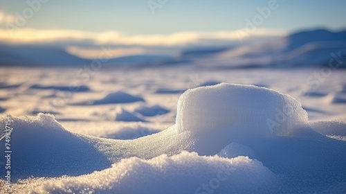 a pile of snow sitting in the middle of a snow covered field with mountains in the distance in the distance. © Anna