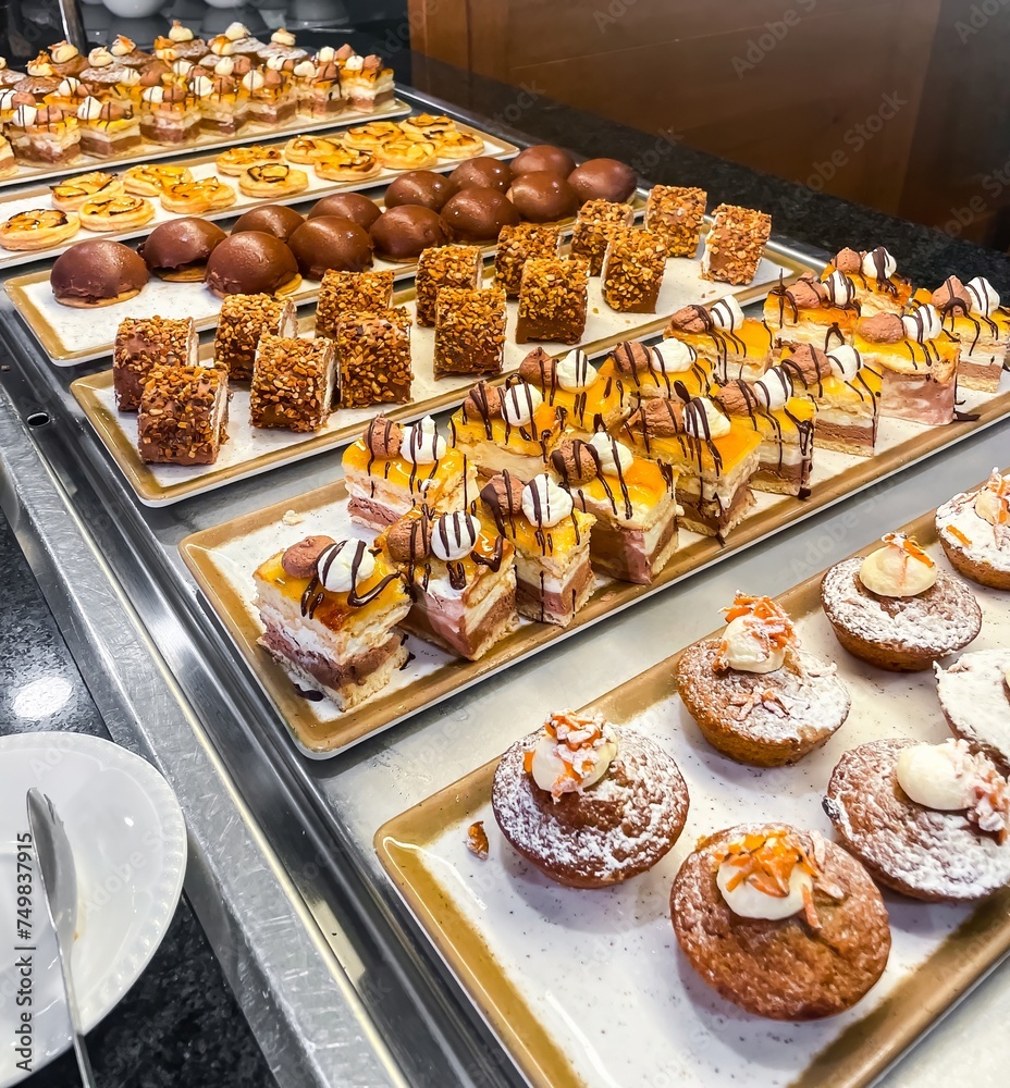 Assortment of small cakes and sweets at a hotel buffet.