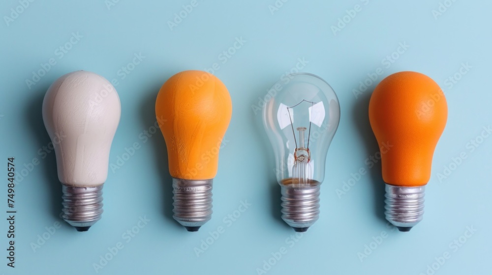 a row of light bulbs sitting next to each other on a blue surface with an orange light bulb in the middle of the row. a row of light bulbs sitting next to each other on a blue surface with an orange light bulb in the middle of the row.