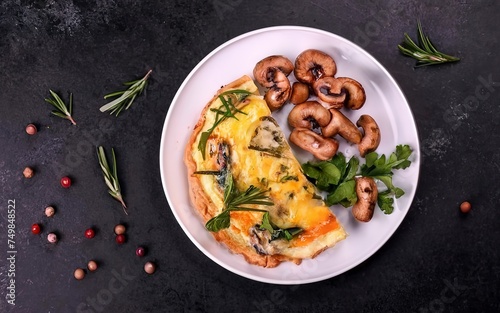 Omelette with cheese, green herbs and fried mushrooms on plate