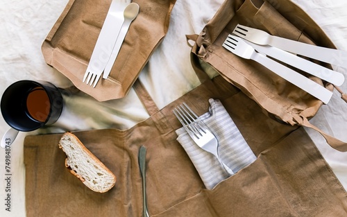 Paper bag with a picnic set plate, fork, glass, napkins. Caring for the environment