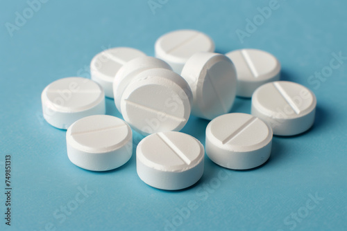 A pile of white pills on a blue surface