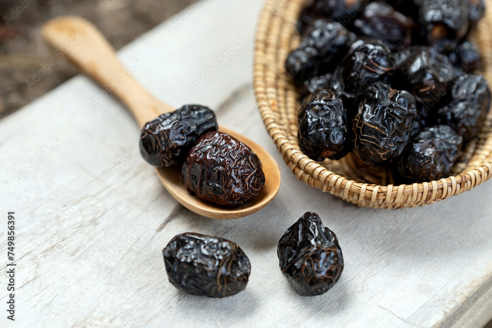 Dried ajwa dates in a wooden bowl on a white wooden background are food for breaking the fast during the Islamic month of Ramadan. Dried ajwa dates in a wooden bowl on a white wooden background are food for breaking the fast during the Islamic month of Ramadan.