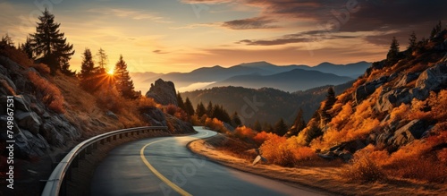 Road in beautiful autumn forest mountains at sunset