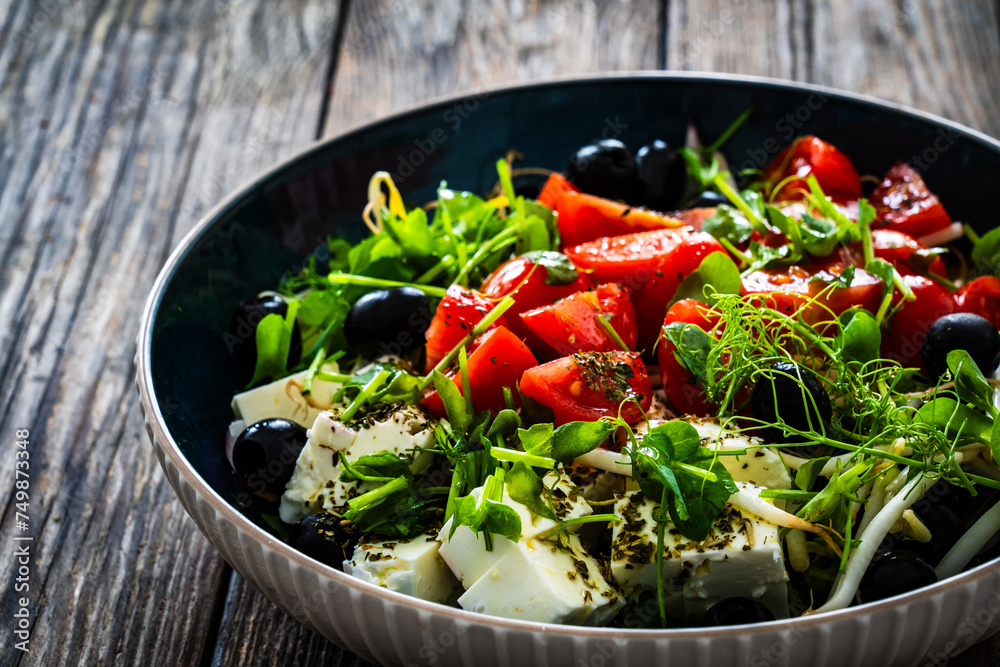 Greek style salad - fresh vegetables with feta cheese on wooden table
Greek style salad - fresh vegetables with feta cheese on wooden table