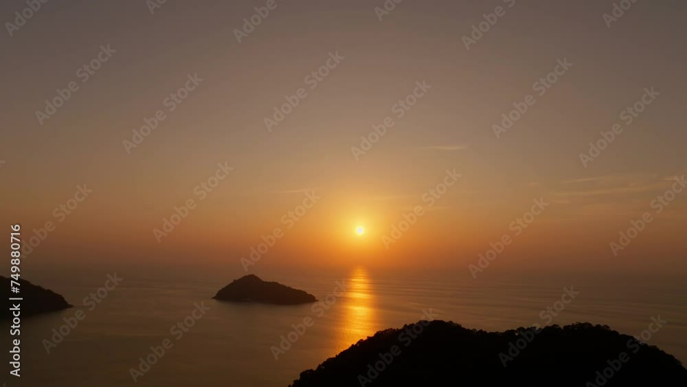 The sunset in the island as silhouettes on tropical summer beach at vivid sunset time The sunset in the island as silhouettes on tropical summer beach at vivid sunset time