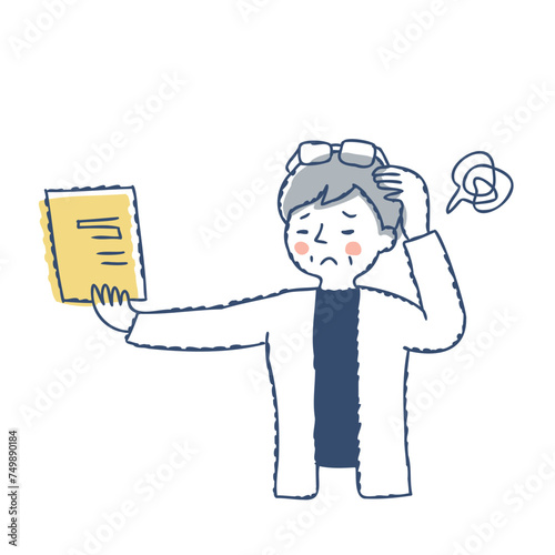 書類を遠ざけて見ている老眼のシニア女性