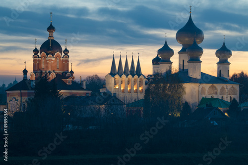 Temples of the ancient Tikhvin Assumption monastery against the background of a cloudy sunset sky on a October twilight. Leningrad Oblast, Russia
