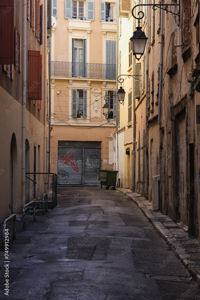 Romantic backstreet road alley in historic old town downtown Toulon, France with Mediterranean style house building facades and old little piazzas fountains picturesque city scenery