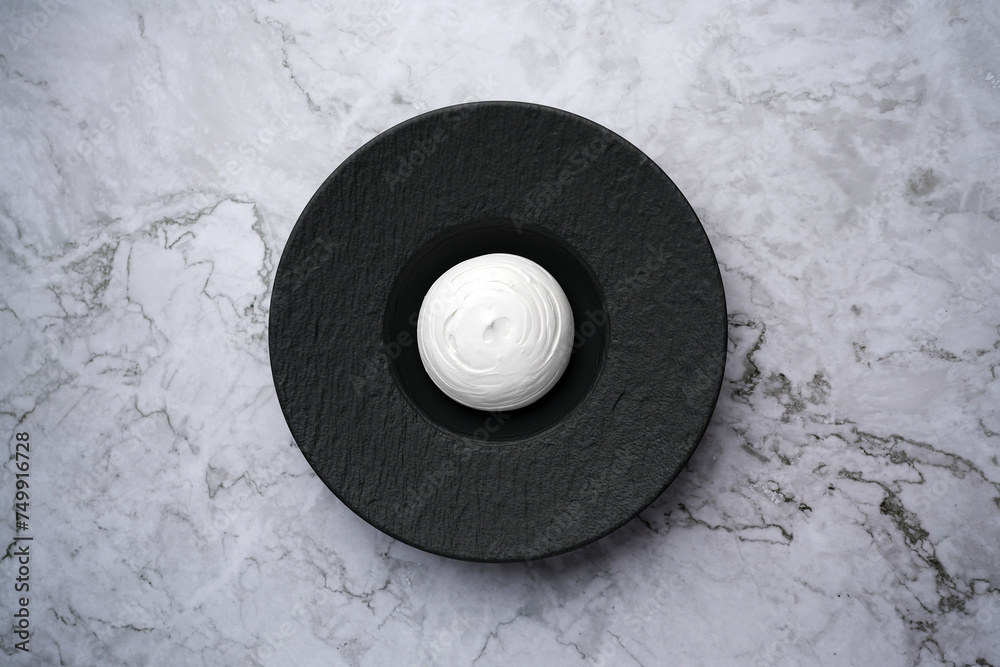 Obraz premium Pavlova dessert, meringue cake on a black plate