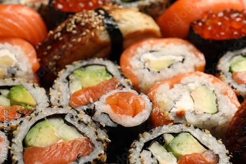 Different tasty sushi rolls as background, closeup