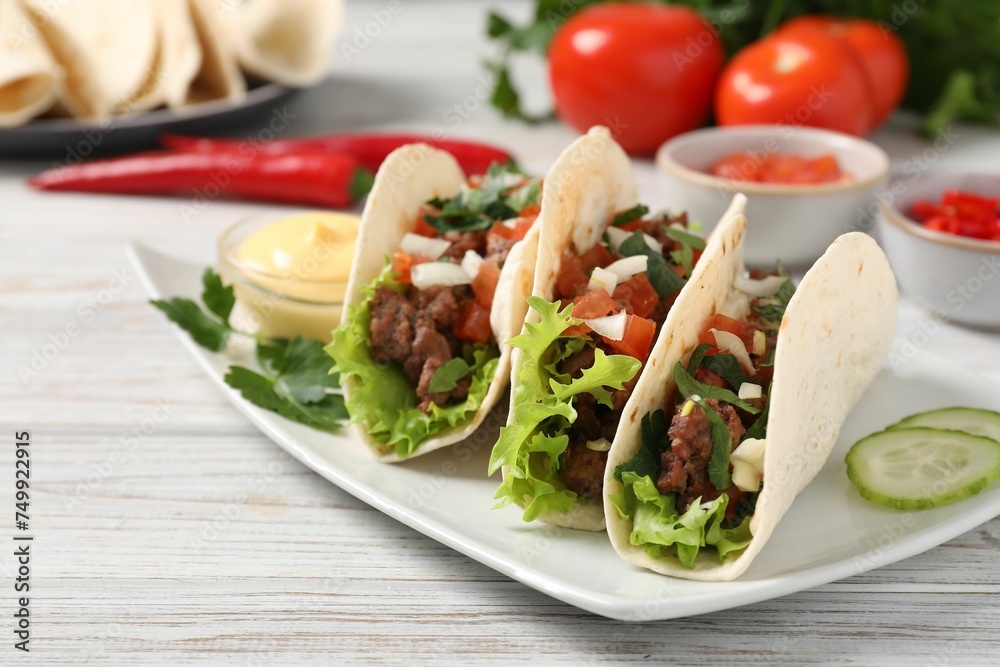 Delicious tacos with meat and vegetables on wooden table, closeup Delicious tacos with meat and vegetables on wooden table, closeup