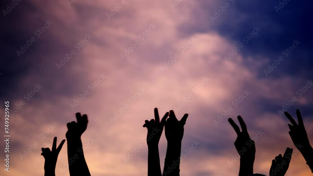 Silhouette on white of hands gesturing victory with sunset background