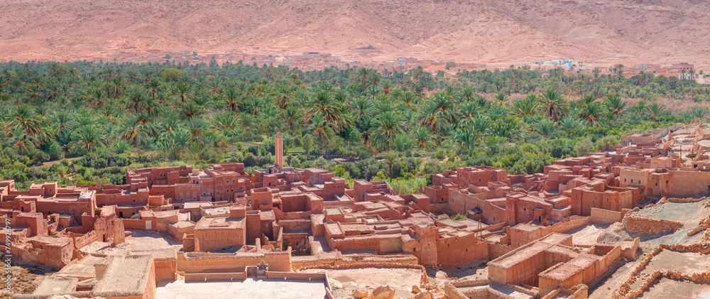 Old kasbah in Tinerhir, typical Moroccan town beside an oasis in Dades Valley - Ancient Berber village, lush green oasis in valley surrounded by the Atlas - Mountains - Tinghir, Morocco - obrazy, fototapety, plakaty 