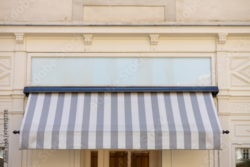 Gray and white awning over the windows on the white wall