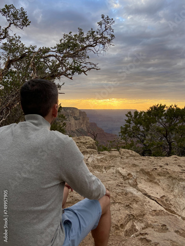 Obraz na płótnie A tourist man enjoying the view of the South Rim of the Grand Canyon National Park at sunset. w salonie