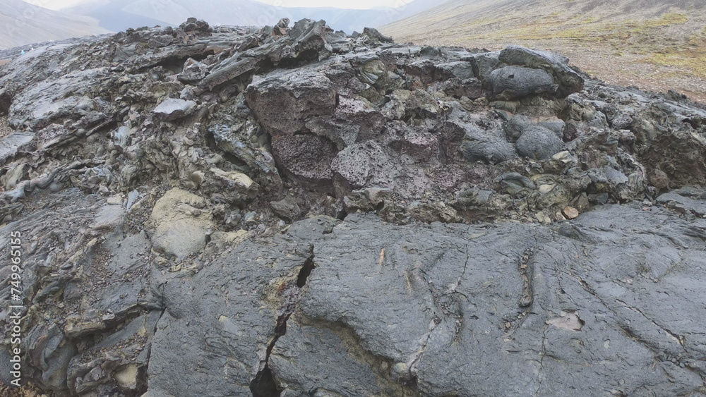 View of cracked lava crust or ingenious rock and steam cooled down from the 2021 eruption of Fagradalsfjall volcano in Geldingadalir Valley on Reykjanes Peninsula in Iceland.