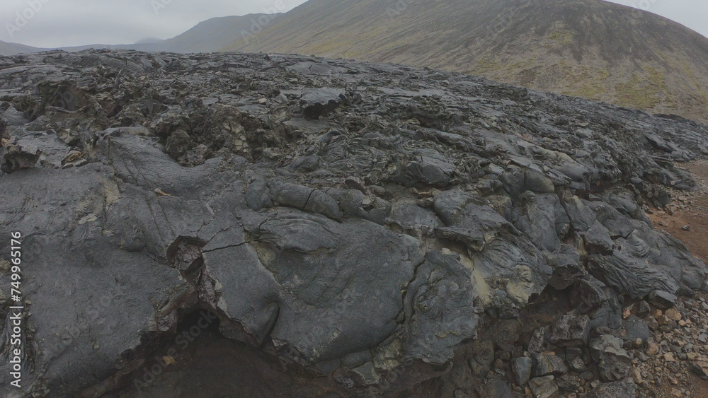 View of cracked lava crust or ingenious rock and steam cooled down from the 2021 eruption of Fagradalsfjall volcano in Geldingadalir Valley on Reykjanes Peninsula in Iceland.